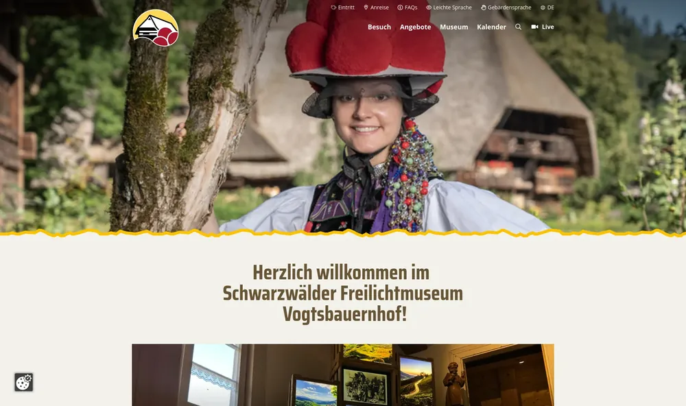 Website des Schwarzwälder Freilichtmuseums Vogtsbauernhof: Frau mit traditionellem Bollenhut vor historischen Schwarzwaldhäusern